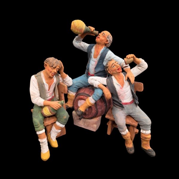 Tre statuine in terracotta che brindano in onore del dio Bacco.